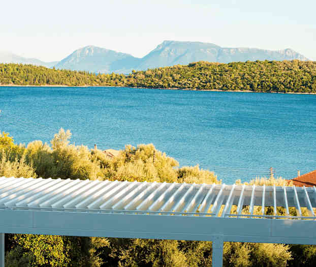 Utsikt över havet med träd och en terrass i förgrunden. (AI-genererad text)
