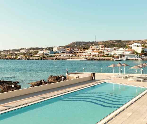 Bild av en pool med utsikt över havet och en kuststad. (AI-genererad text)