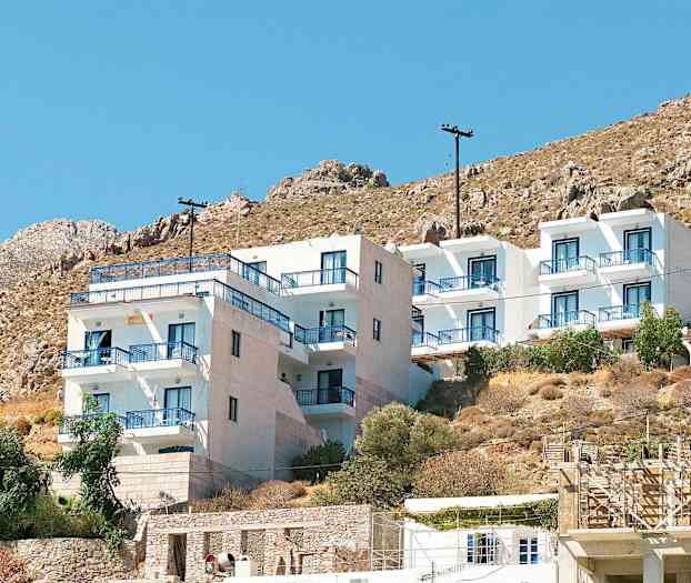 Vit byggnad med blå balkongräcken vid en bergssluttning. (AI-genererad text)