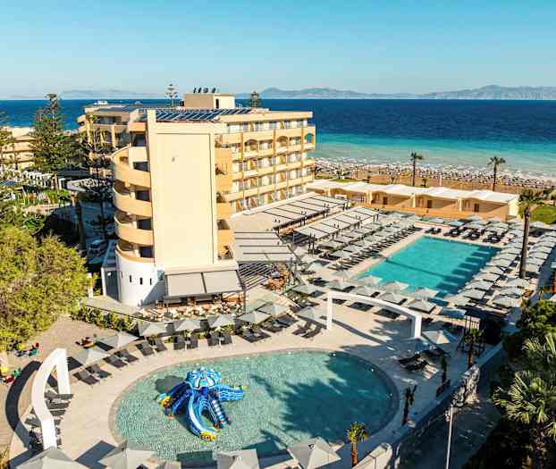 En strandnära resort med pool, solstolar och gröna omgivningar. (AI-genererad text)