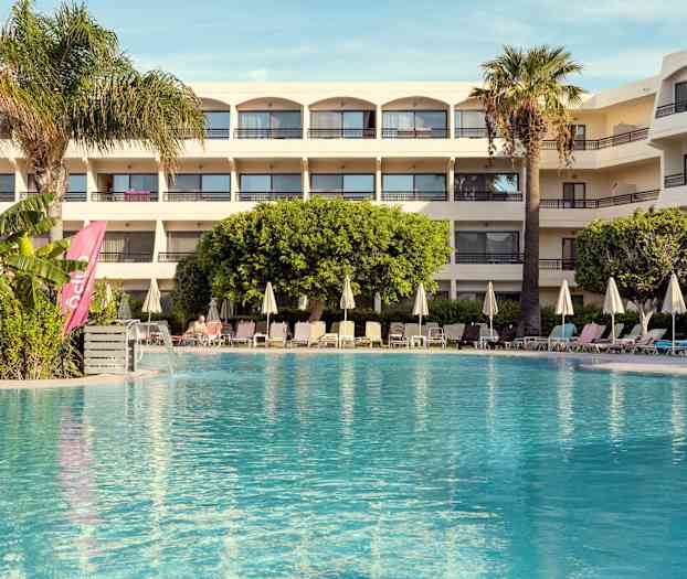 Hotell med pool och solstolar i förgrunden. (AI-genererad text)