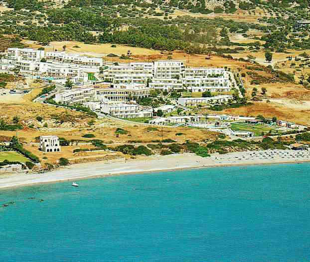 Vy över hotell och byggnader på en sluttning nära en strand med solstolar och blått hav. (AI-genererad text)