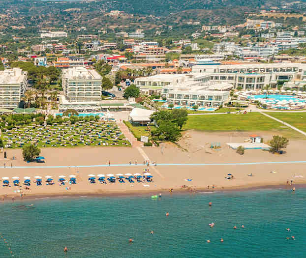 Hotellanläggning vid en sandstrand med solstolar och parasoller. (AI-genererad text)