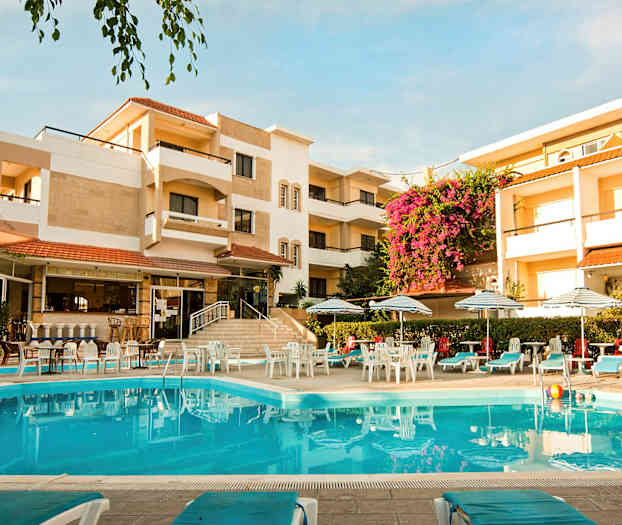 Hotellbyggnad med en pool i förgrunden och omgiven av solstolar och parasoller. (AI-genererad text)