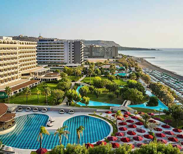 Hotellanläggning med pooler, grönområden och strand. (AI-genererad text)