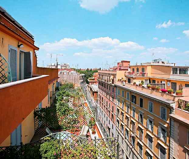 Vy över bostadshus från en balkong, med himmel och moln i bakgrunden. (AI-genererad text)