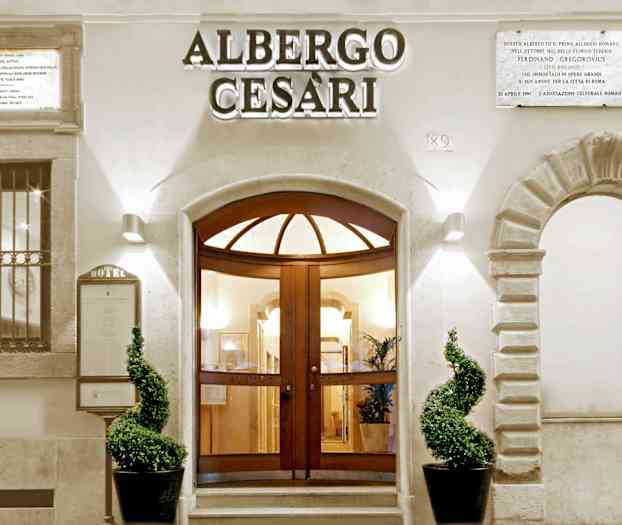 Hotellentré med välformade växter och dekorativ arkitektur. (AI-genererad text)