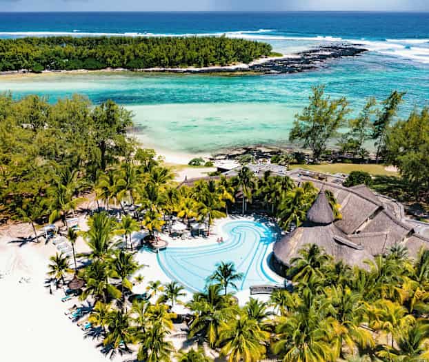 Strand och poolområde med palmer och turkost vatten. (AI-genererad text)