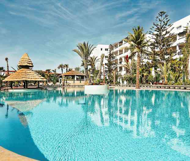 En pool med parasoll och omgivande palmer. (AI-genererad text)