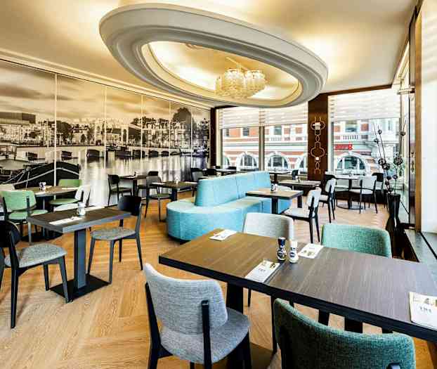 En restaurang interiör med moderna möbler och stort fototapet av en stadsutsikt på väggen. (AI-genererad text)