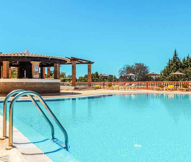 Poolområde med solstolar, parasoller och en bar vid kanten. (AI-genererad text)