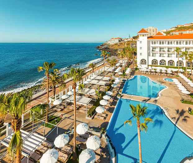 Hotell med poolområde och utsikt mot havet. (AI-genererad text)