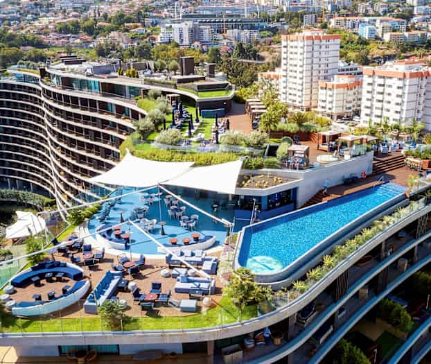 Hotellkomplex med terrass, pool och sittgrupper. (AI-genererad text)