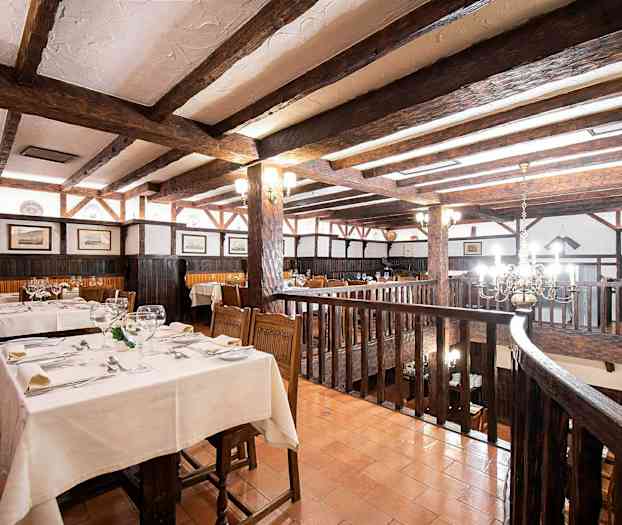 Rustik restaurang med träbjälkar och dukade bord. (AI-genererad text)