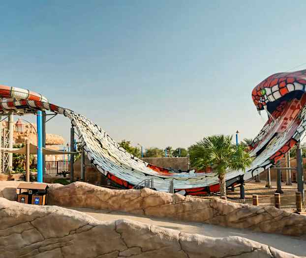 En stor vattenrutschkana formad som ett ormliknande motiv i en nöjespark. (AI-genererad text)