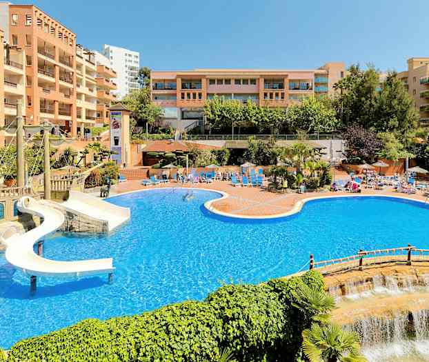 Stort poolområde med vattenrutschbana och omgivande hotellbyggnader. (AI-genererad text)