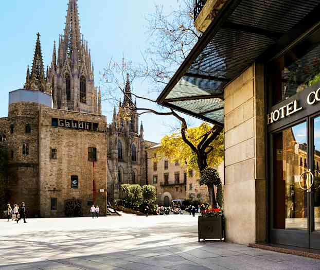 Hotell Colon i förgrunden, med kyrkan La Catedral de Barcelona i bakgrunden. (AI-genererad text)