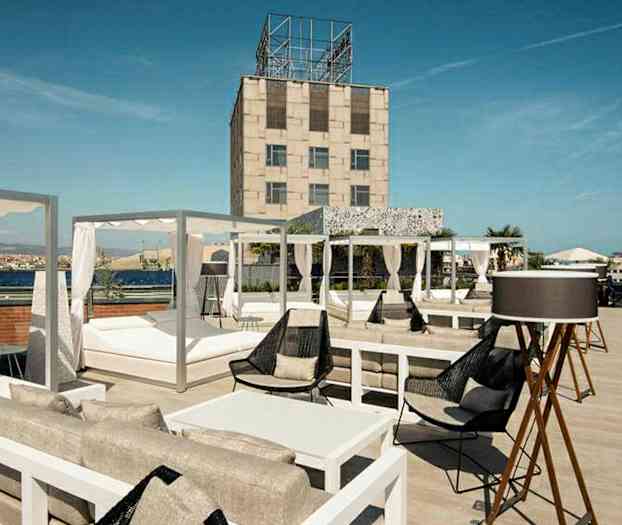 En takterrass med sittgrupper, solsängar och utsikt över omgivningen. (AI-genererad text)