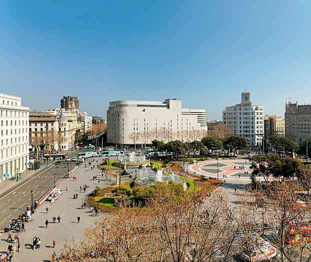 En bild av ett torg omgivet av byggnader med en fontän och människor som promenerar. (AI-genererad text)