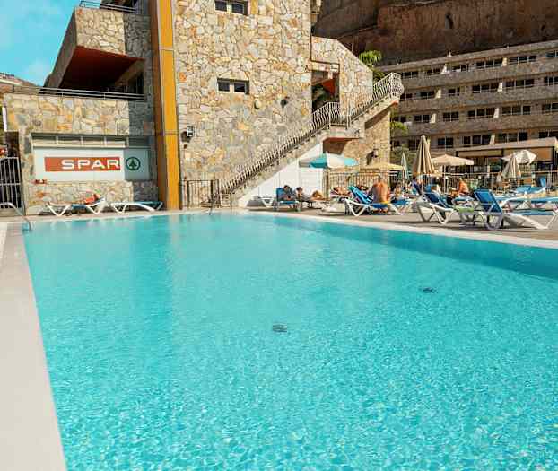 Utomhuspool vid hotell med solstolar och parasoller. (AI-genererad text)