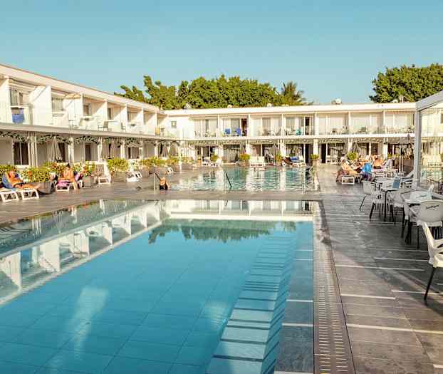 Hotellområde med pool, solstolar och sittplatser. (AI-genererad text)