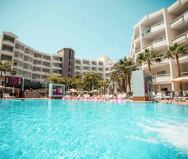 En hotellpool vid ett större byggnadskomplex. (AI-genererad text)