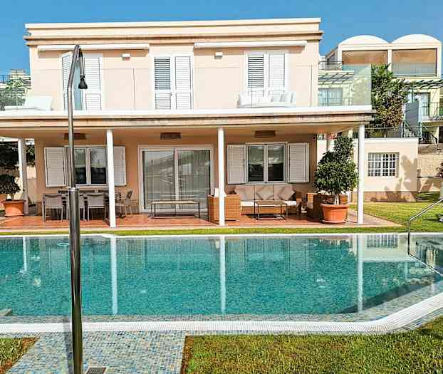 En villa med två våningar, solterrass och pool. (AI-genererad text)