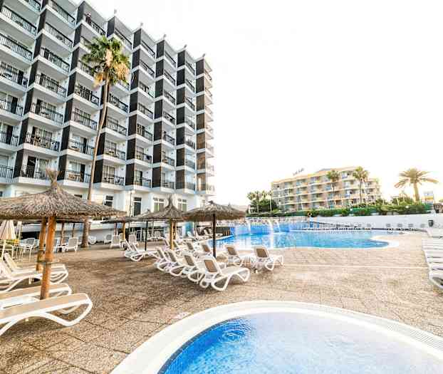 Bild av ett hotellområde med pool, solstolar och parasoll. (AI-genererad text)