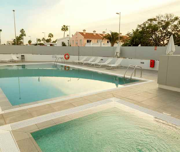 En utomhuspool med solstolar bredvid. (AI-genererad text)