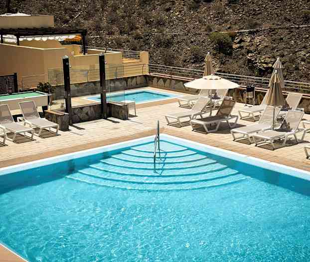 Utomhuspool med solstolar och parasoller vid sidan. (AI-genererad text)