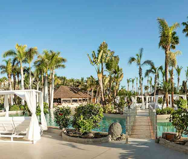 Solig resort med pool, palmer, träpergola och planteringar. (AI-genererad text)