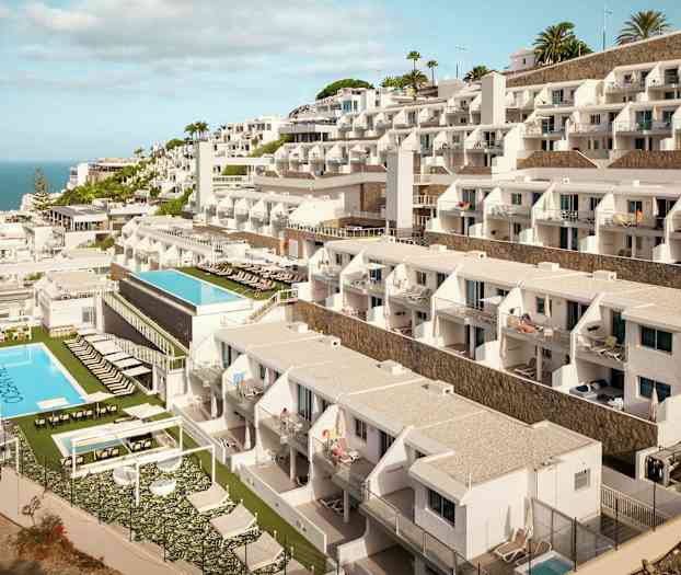 Hotellbyggnad med flera våningar och pool mot havet. (AI-genererad text)