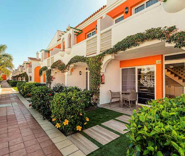 Rad av semesterlägenheter med privata uteplatser och trädgård. (AI-genererad text)