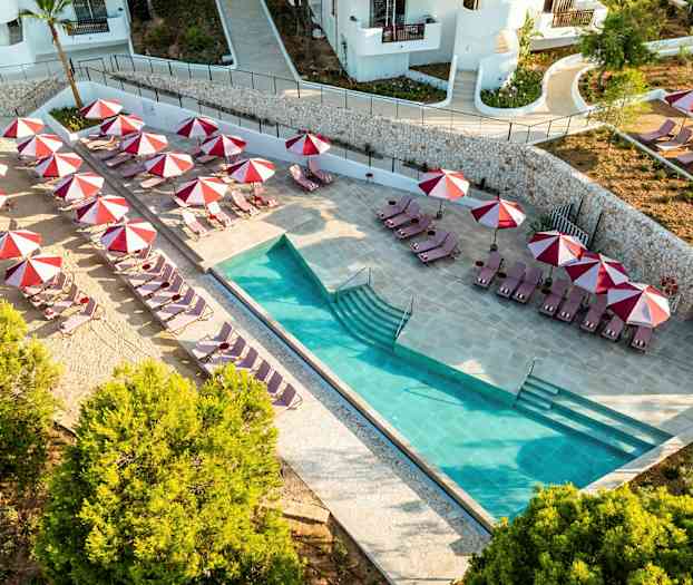 Poolområde med solstolar och röda parasoller. (AI-genererad text)