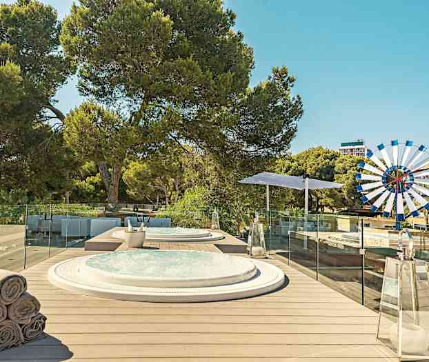 Terrass med bubbelpooler, solstolar och frodig grönska. (AI-genererad text)