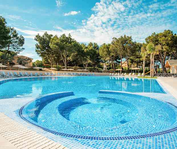 Utomhuspool omgiven av solstolar och träd. (AI-genererad text)