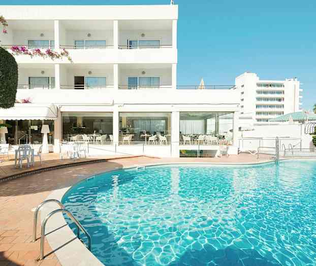 Hotellbyggnad med en utomhuspool i förgrunden. (AI-genererad text)