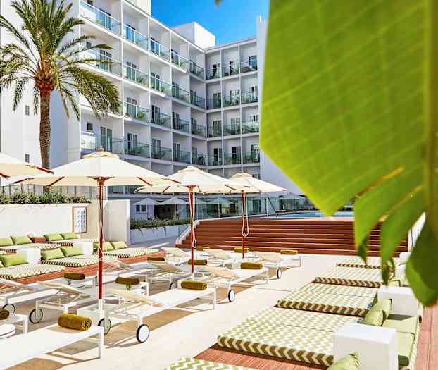 Hotellpoolområde med solstolar, parasoller och ett flervåningshus i bakgrunden. (AI-genererad text)