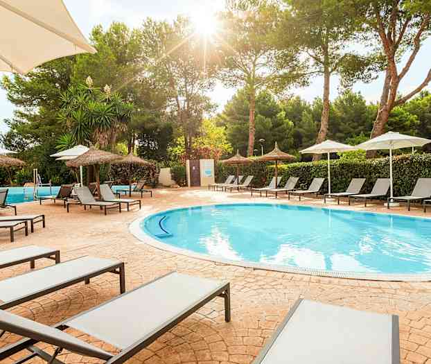 Solstolar vid en pool med parasoller och träd i bakgrunden. (AI-genererad text)