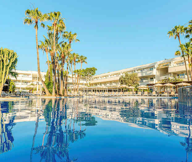 Bild av ett hotell med palmer vid en pool. (AI-genererad text)