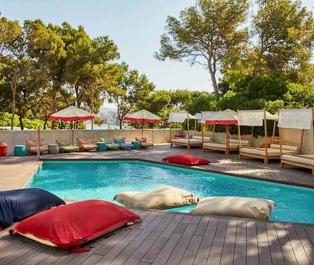 En utomhuspool omgiven av solsängar och parasoller. (AI-genererad text)