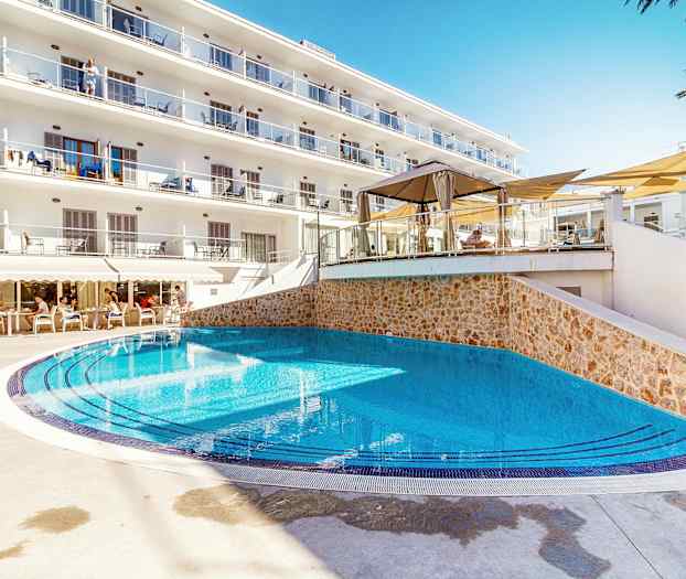 Utomhuspool vid hotell med solstolar och balkonger. (AI-genererad text)