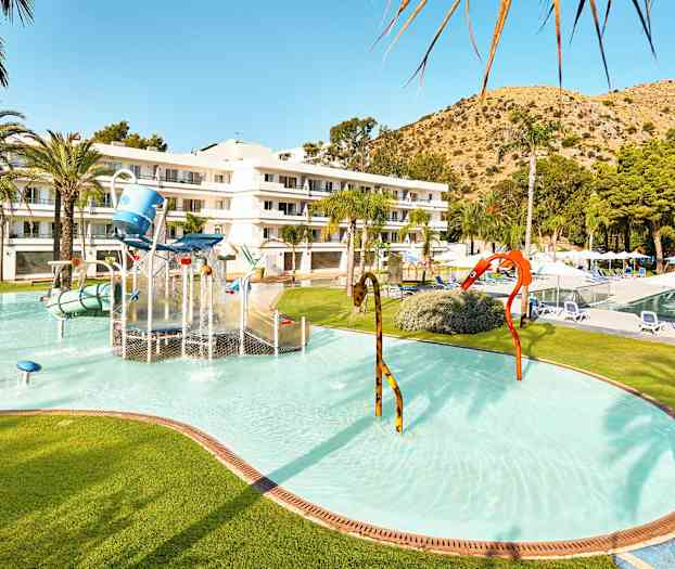 Barnpool med vattenlek och hotellbyggnad i bakgrunden. (AI-genererad text)