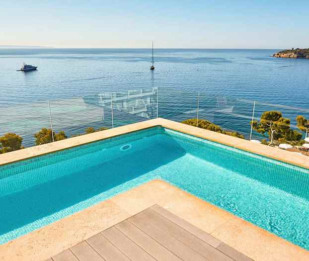 Bild på en pool med utsikt över havet och båtar. (AI-genererad text)