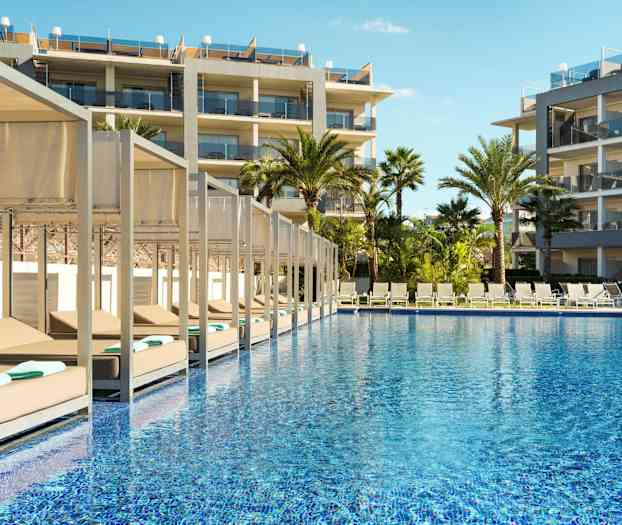 Utemiljö med pool, solstolar och hotellbyggnader. (AI-genererad text)