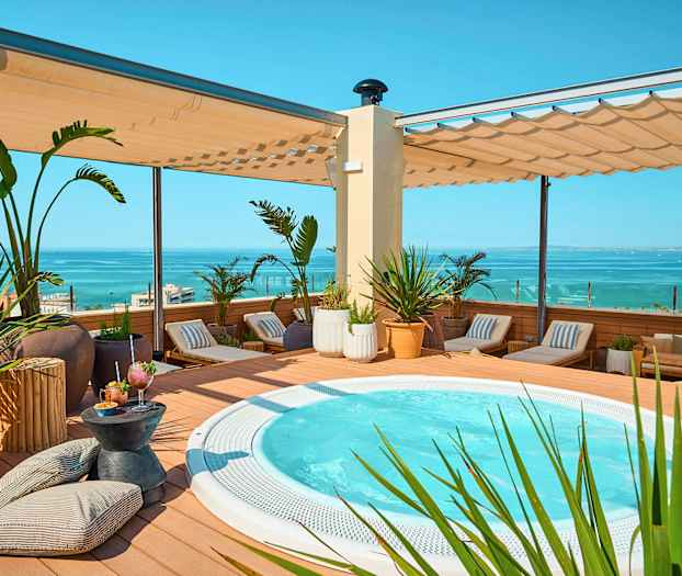 Terrass med jacuzzi, solstolar och havsutsikt. (AI-genererad text)