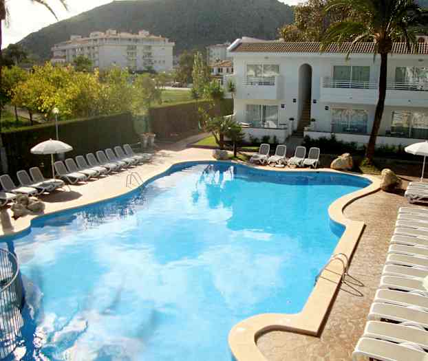 Stor pool omgiven av solstolar och parasoller vid ett hotell. (AI-genererad text)