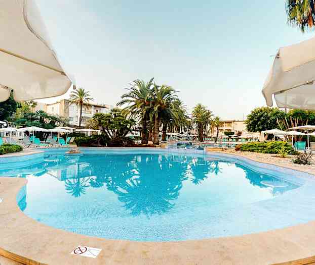 Stora poolen omgiven av parasoller och palmer vid hotellet. (AI-genererad text)