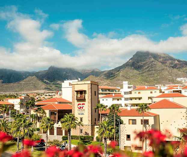 Vy över hotellregion med berg i bakgrunden under en blå himmel. (AI-genererad text)