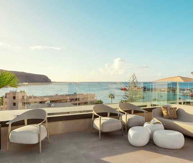 En terrass med sittplatser och utsikt över havet och en hamn. (AI-genererad text)